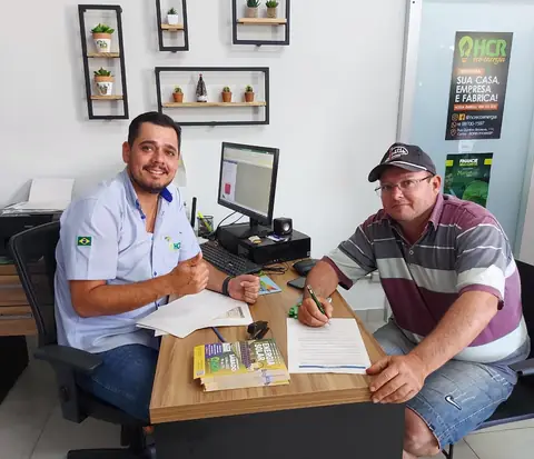 Cliente assinando proposta com consultor da HCR Eco Energia