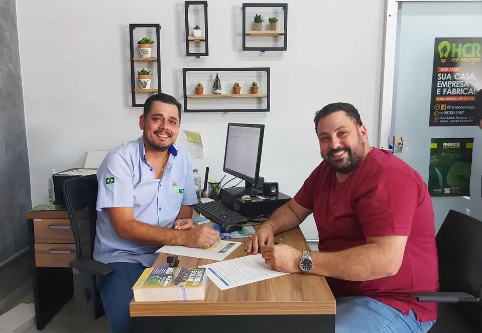 Consultor da HCR Eco Energia atendendo cliente no escritório