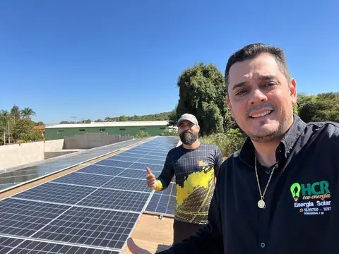Equipe da HCR em cobertura com sistema solar recém-instalado